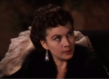 Movie still from “Gone with the Wind” (1939), directed by George Cukor – A woman in a black coat and a diamond earring; Close Up shot, Over the shoulder angle