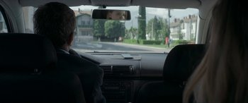 Movie still from “Graduation” (2016), directed by Cristian Mungiu – A man sitting in the back seat of a car looking out the window; Medium shot, Over the shoulder angle