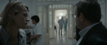 Movie still from “Graduation” (2016), directed by Cristian Mungiu – A group of people in a room with a door open; Close Up shot, Over the shoulder angle