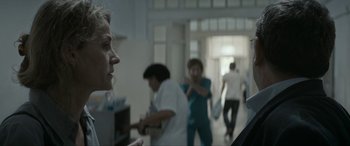 Movie still from “Graduation” (2016), directed by Cristian Mungiu – A group of people standing in a room; Close Up shot, Over the shoulder angle