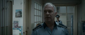 Movie still from “Graduation” (2016), directed by Cristian Mungiu – A person wearing a police uniform; Close Up shot, Over the shoulder angle