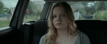 Movie still from “Graduation” (2016), directed by Cristian Mungiu – A woman sitting in the back seat of a car; Close Up shot, Over the shoulder angle