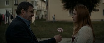 Movie still from “Graduation” (2016), directed by Cristian Mungiu – A man and a woman holding a flower in their hands; Medium shot, Over the shoulder angle