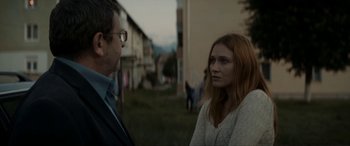 Movie still from “Graduation” (2016), directed by Cristian Mungiu – A man and a woman standing next to each other outside; Medium shot, Over the shoulder angle
