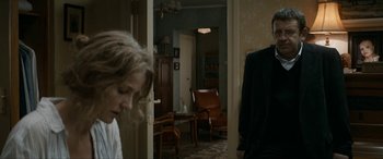 Movie still from “Graduation” (2016), directed by Cristian Mungiu – A man and a woman standing in a living room; Medium shot, Over the shoulder angle