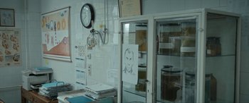 Movie still from “Graduation” (2016), directed by Cristian Mungiu – A room filled with lots of papers and a clock; Medium shot, Low angle