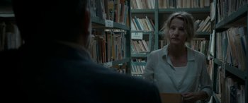 Movie still from “Graduation” (2016), directed by Cristian Mungiu – Two people sitting in front of a book shelf in a library; Medium shot, Over the shoulder angle
