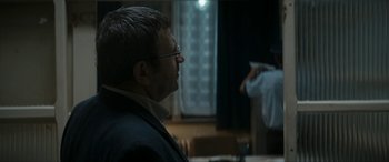 Movie still from “Graduation” (2016), directed by Cristian Mungiu – A man with glasses is looking at a man in a suit; Close Up shot, Over the shoulder angle