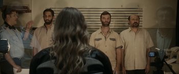 Movie still from “Graduation” (2016), directed by Cristian Mungiu – A group of men standing next to each other in front of a woman; Medium shot, Over the shoulder angle