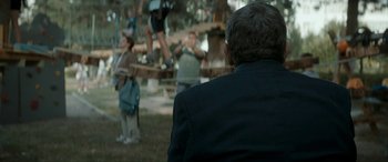 Movie still from “Graduation” (2016), directed by Cristian Mungiu – A group of people standing on a rope bridge; Medium shot, Over the shoulder angle