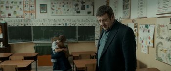 Movie still from “Graduation” (2016), directed by Cristian Mungiu – A man standing in front of a chalkboard with two children; Medium shot, Over the shoulder angle