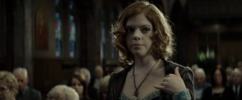 Movie still from “Gran Torino” (2008), directed by Clint Eastwood – A person wearing a necklace in a room; Close Up shot, Over the shoulder angle