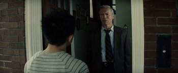 Movie still from “Gran Torino” (2008), directed by Clint Eastwood – An older man wearing a suit and tie talking to a young man; Medium shot, Over the shoulder angle