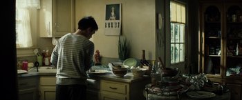 Movie still from “Gran Torino” (2008), directed by Clint Eastwood – A man standing in a kitchen preparing a meal; Medium shot, Over the shoulder angle