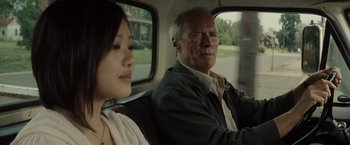 Movie still from “Gran Torino” (2008), directed by Clint Eastwood – A man and a woman sitting in the back of a car; Close Up shot, Over the shoulder angle