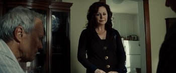 Movie still from “Gran Torino” (2008), directed by Clint Eastwood – A woman standing in front of a mirror in a room; Medium shot, Over the shoulder angle