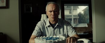 Movie still from “Gran Torino” (2008), directed by Clint Eastwood – An older man sitting in front of a birthday cake; Close Up shot, Over the shoulder angle