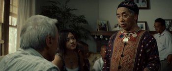 Movie still from “Gran Torino” (2008), directed by Clint Eastwood – A group of people standing around a living room; Medium shot, Over the shoulder angle