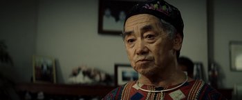 Movie still from “Gran Torino” (2008), directed by Clint Eastwood – An older man wearing a hat looking at the camera; Close Up shot, Over the shoulder angle