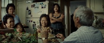 Movie still from “Gran Torino” (2008), directed by Clint Eastwood – Two women sitting at a table with a plate of food in front of them; Medium shot, Over the shoulder angle