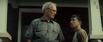 Movie still from “Gran Torino” (2008), directed by Clint Eastwood – An older man wearing glasses and a gray shirt; Close Up shot, Over the shoulder angle