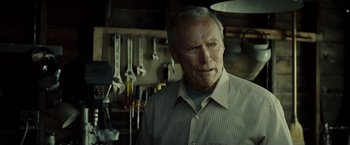 Movie still from “Gran Torino” (2008), directed by Clint Eastwood – An older man standing in front of some tools; Close Up shot, Over the shoulder angle