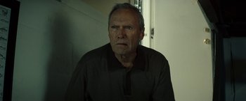 Movie still from “Gran Torino” (2008), directed by Clint Eastwood – An older man with gray hair stares into the camera; Close Up shot, Low angle