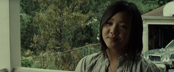 Movie still from “Gran Torino” (2008), directed by Clint Eastwood – A young woman is smiling for the camera outside; Close Up shot, Over the shoulder angle