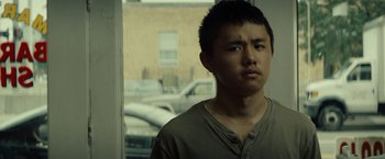 Movie still from “Gran Torino” (2008), directed by Clint Eastwood – A young man looking out of a window; Close Up shot, Low angle