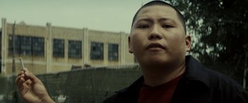 Movie still from “Gran Torino” (2008), directed by Clint Eastwood – A man in a red shirt and a black jacket; Close Up shot, Low angle