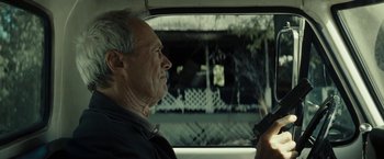 Movie still from “Gran Torino” (2008), directed by Clint Eastwood – An older man sitting in the back seat of a car; Close Up shot, Over the shoulder angle