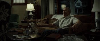 Movie still from “Gran Torino” (2008), directed by Clint Eastwood – An older man sitting on a couch with a dog; Medium shot, Over the shoulder angle