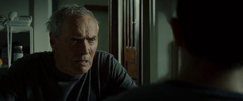 Movie still from “Gran Torino” (2008), directed by Clint Eastwood – An older man sitting in front of a window; Close Up shot, Over the shoulder angle