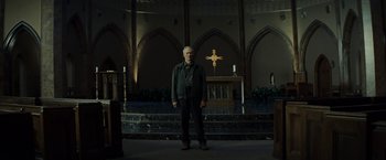 Movie still from “Gran Torino” (2008), directed by Clint Eastwood – A man standing in front of an altar in a church; Wide shot, Low angle