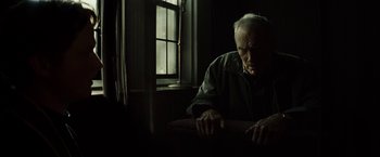 Movie still from “Gran Torino” (2008), directed by Clint Eastwood – An older man sitting in front of a computer monitor; Medium shot, Low angle