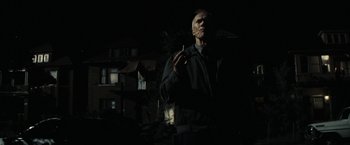 Movie still from “Gran Torino” (2008), directed by Clint Eastwood – An old man smoking a cigarette in the dark; Medium shot, Low angle