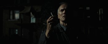 Movie still from “Gran Torino” (2008), directed by Clint Eastwood – An older man smoking a cigarette in the dark; Close Up shot, Low angle