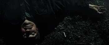 Movie still from “Gran Torino” (2008), directed by Clint Eastwood – A man laying on a pile of mulch next to a cigarette; Close Up shot, Overhead angle