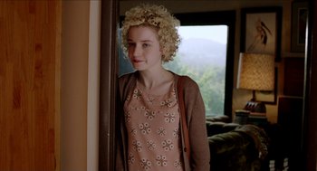Movie still from “Grandma” (2015), directed by Paul Weitz – A young woman standing next to a window in a room; Medium shot, Over the shoulder angle