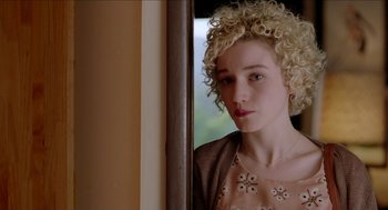 Movie still from “Grandma” (2015), directed by Paul Weitz – A woman with blonde curly hair standing in front of a window; Close Up shot, Over the shoulder angle