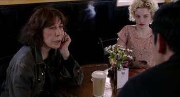 Movie still from “Grandma” (2015), directed by Paul Weitz – Two women are sitting at a table talking on their cell phones; Medium shot, Over the shoulder angle