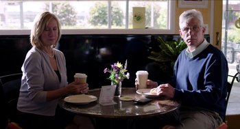 Movie still from “Grandma” (2015), directed by Paul Weitz – A man and a woman sitting at a table with coffee; Medium shot, Over the shoulder angle
