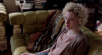 Movie still from “Grandma” (2015), directed by Paul Weitz – A woman sitting on a couch in front of a chair; Medium shot, High angle