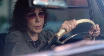 Movie still from “Grandma” (2015), directed by Paul Weitz – A woman driving in a car with sunglasses on; Close Up shot, Over the shoulder angle