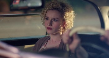 Movie still from “Grandma” (2015), directed by Paul Weitz – A woman with blonde curly hair sitting in the driver's seat of a car; Close Up shot, Over the shoulder angle