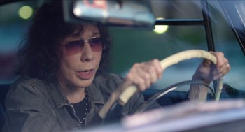 Movie still from “Grandma” (2015), directed by Paul Weitz – A woman driving in a car with sunglasses on; Close Up shot, Over the shoulder angle