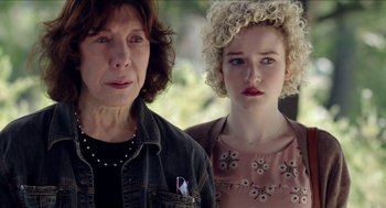 Movie still from “Grandma” (2015), directed by Paul Weitz – A woman standing next to a woman with curly blonde hair; Close Up shot, Over the shoulder angle