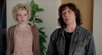 Movie still from “Grandma” (2015), directed by Paul Weitz – Two women standing next to each other in front of a plant; Close Up shot, Over the shoulder angle
