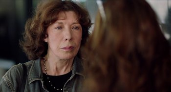 Movie still from “Grandma” (2015), directed by Paul Weitz – An older woman looking at the camera with a serious look on her face; Close Up shot, Over the shoulder angle