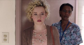 Movie still from “Grandma” (2015), directed by Paul Weitz – A young woman with blonde curly hair wearing a pink dress; Close Up shot, Over the shoulder angle